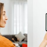 Junge Frau bedient Smart Home Device