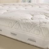 Primo piano di un materasso con superficie strutturata su una rete letto.