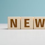 Holzbuchstaben bilden das Wort „NEWS“ auf einem hellen Hintergrund.