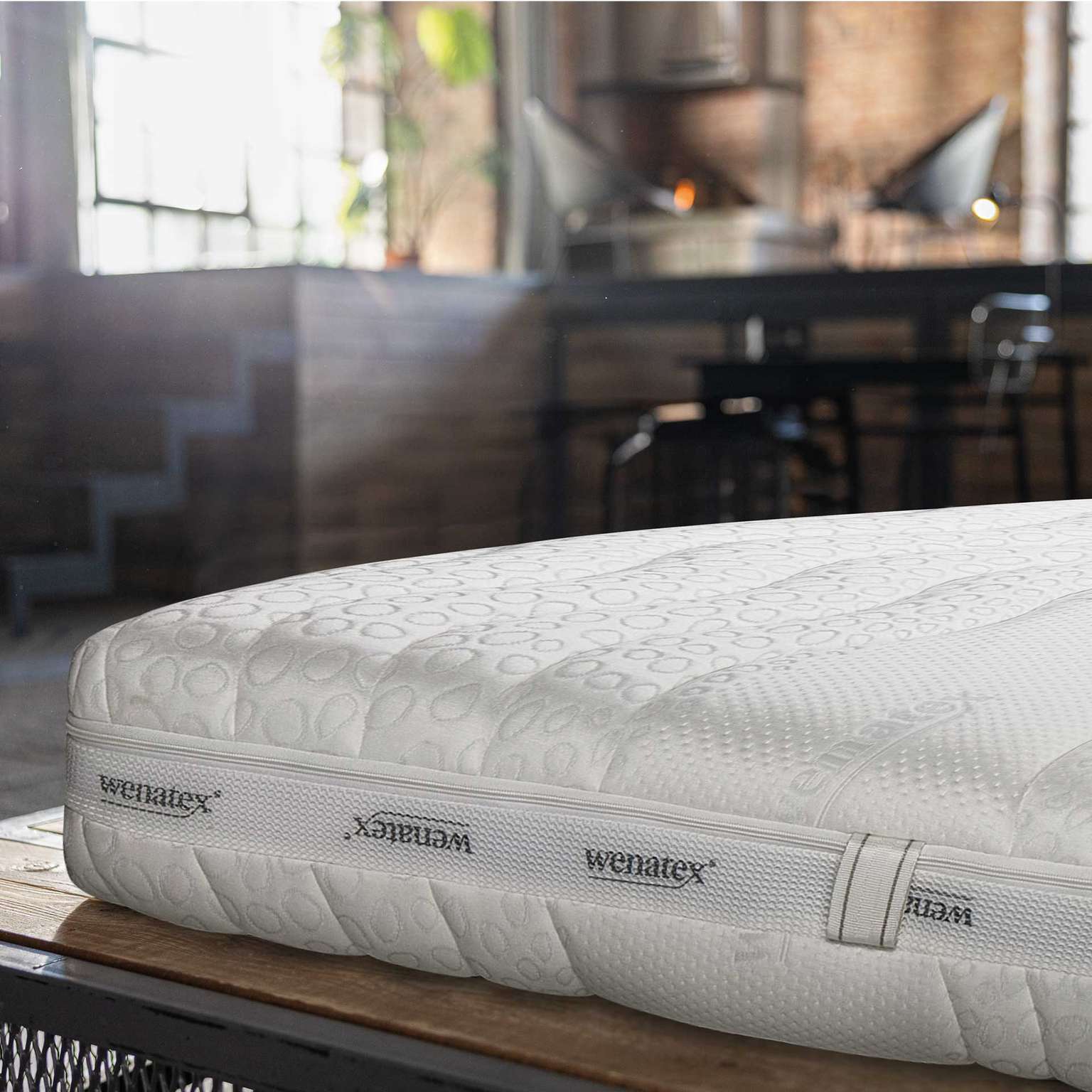Matratze Comfort Plus von Wenatex auf einem Holzgestell in modernem Raum.