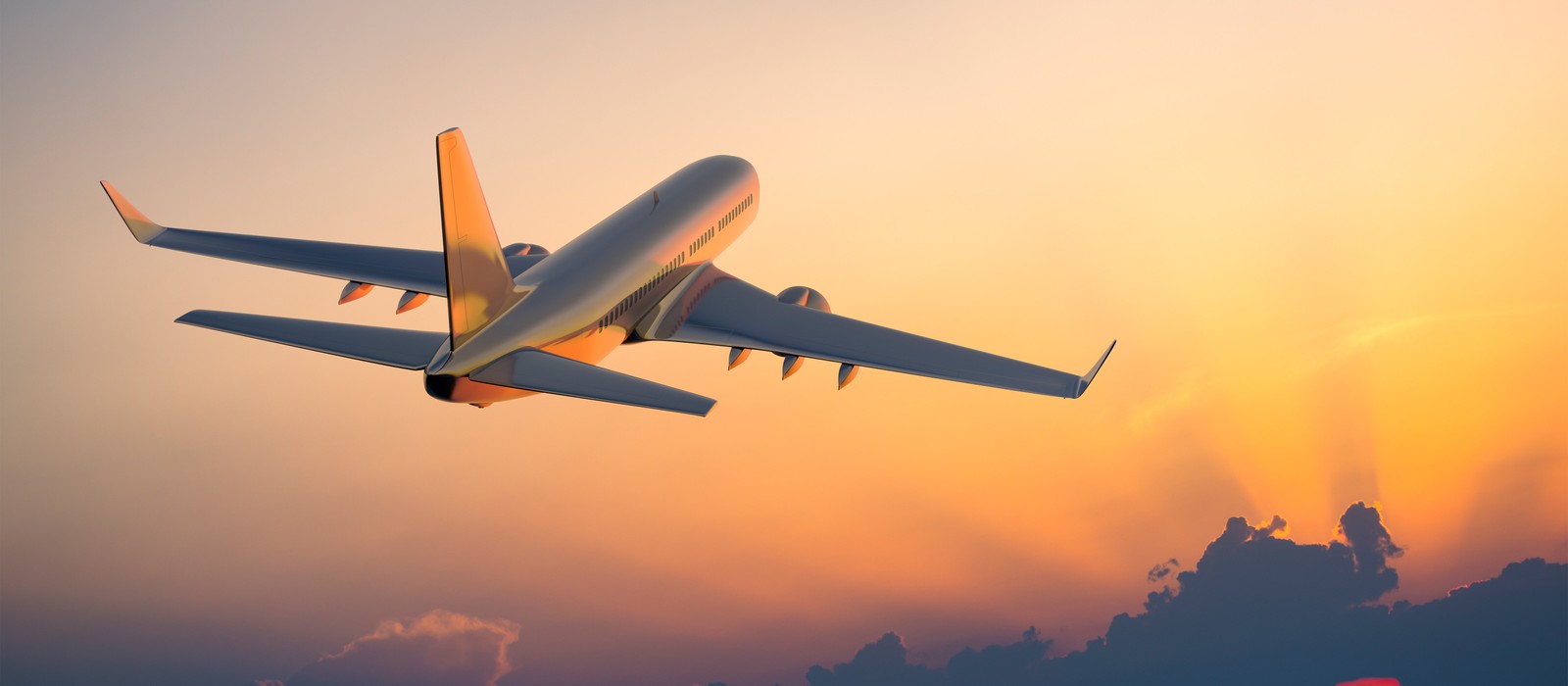 Flugzeug hebt bei Sonnenuntergang ab, symbolisiert Reisen und Schlafkomfort auf langen Strecken.