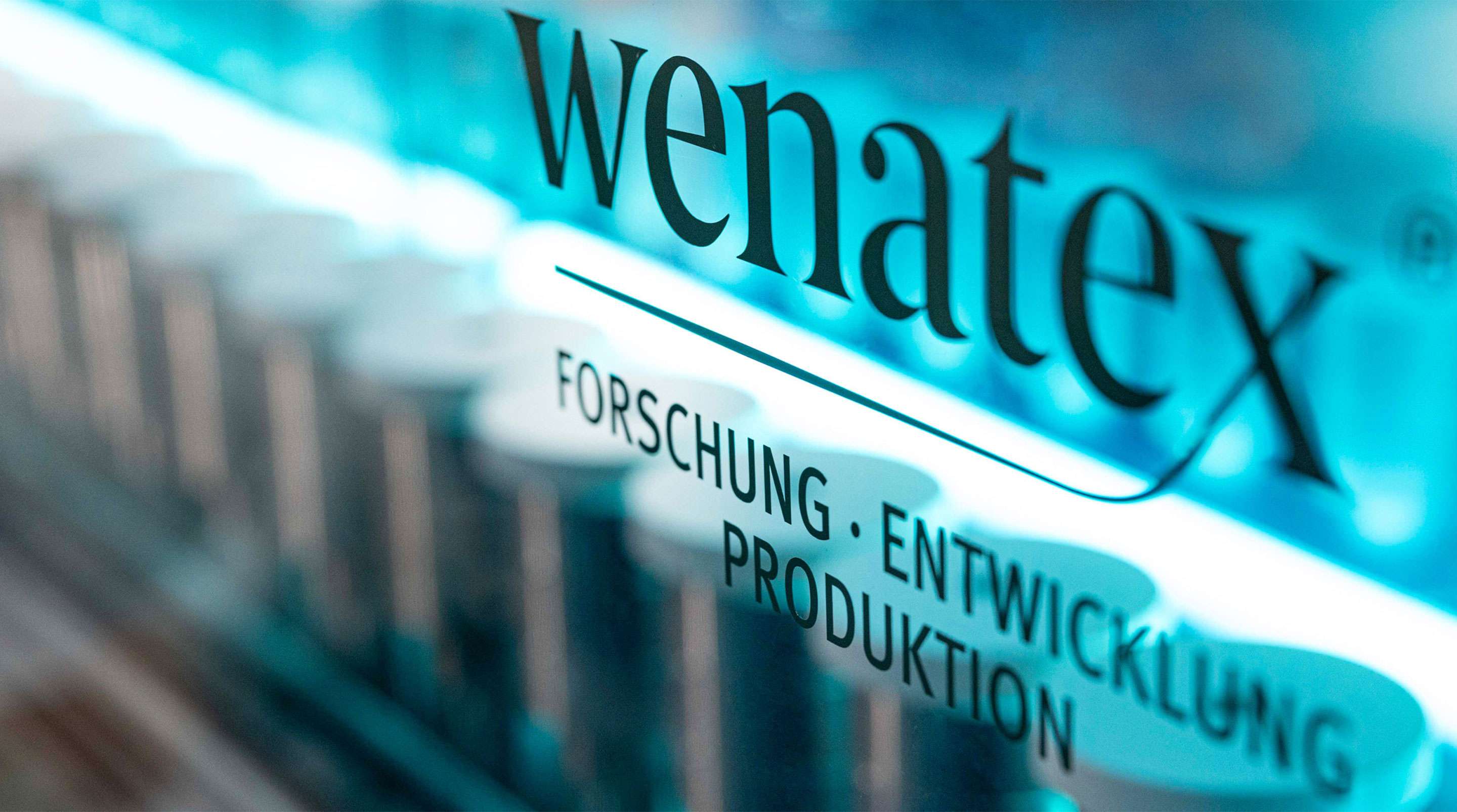 Wenatex Logo mit Fokus auf Forschung, Entwicklung und Produktion in einem modernen Laborumfeld.