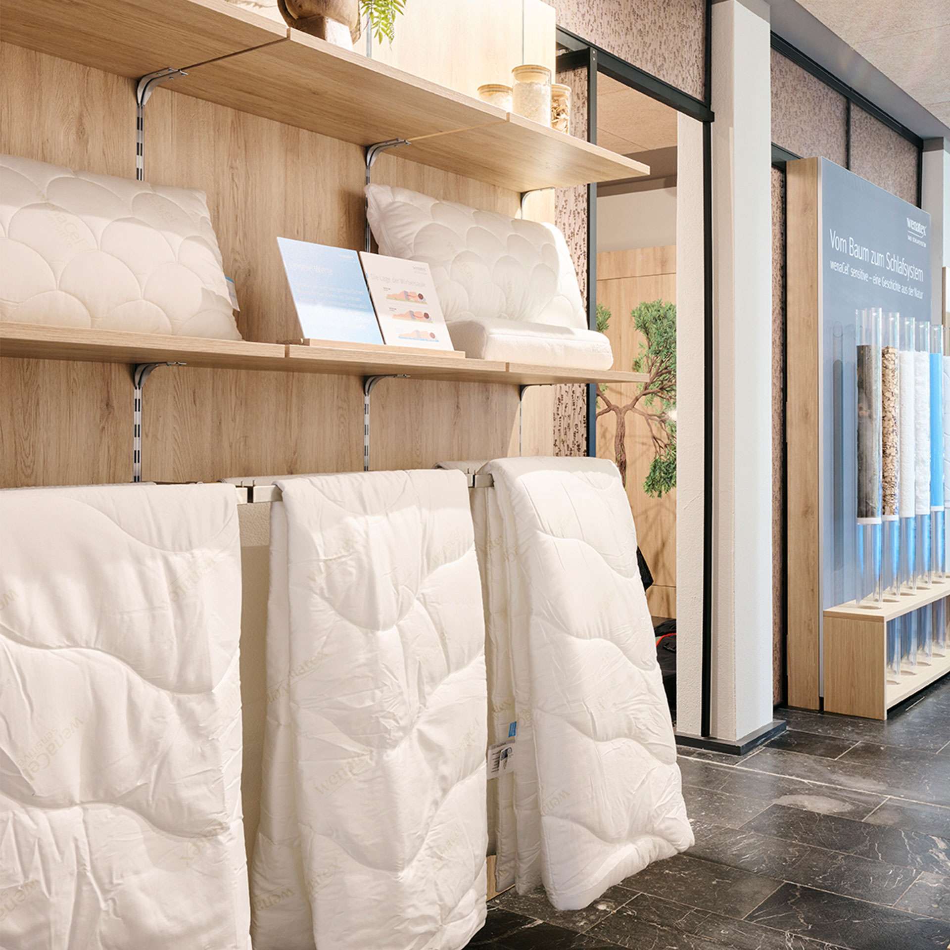 Shelves with white blankets and pillows in a modern interior, wooden shelves and decorative elements in the background.